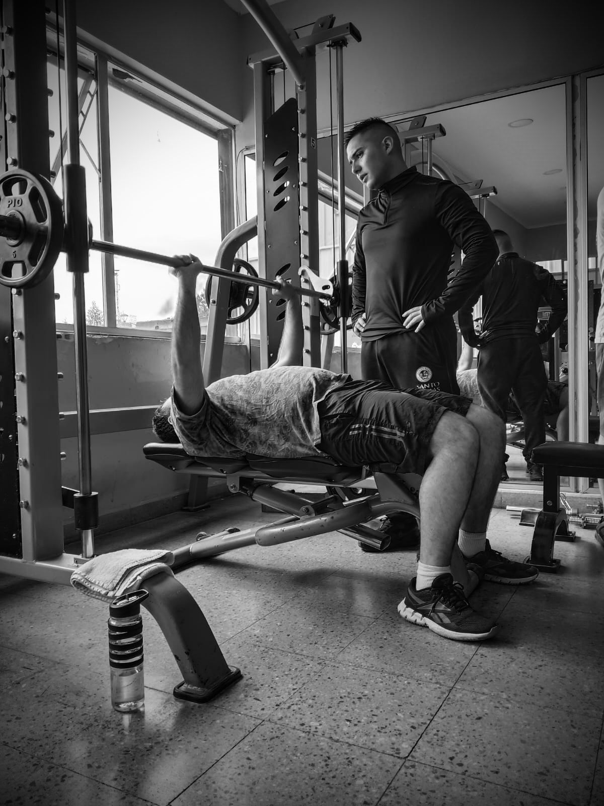 Gustavo Villagra supervisando a un alumno durante press banca